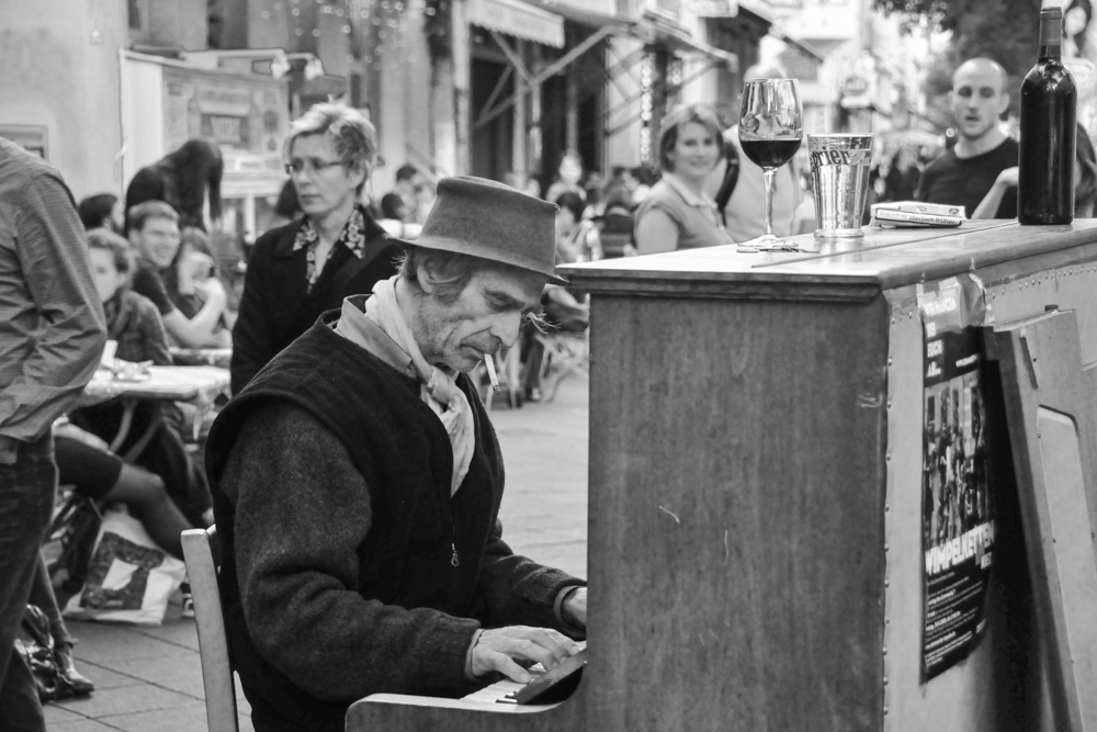Ein Straßenmusiker spielt auf seinem rollenden Piano Ragtime-Musik